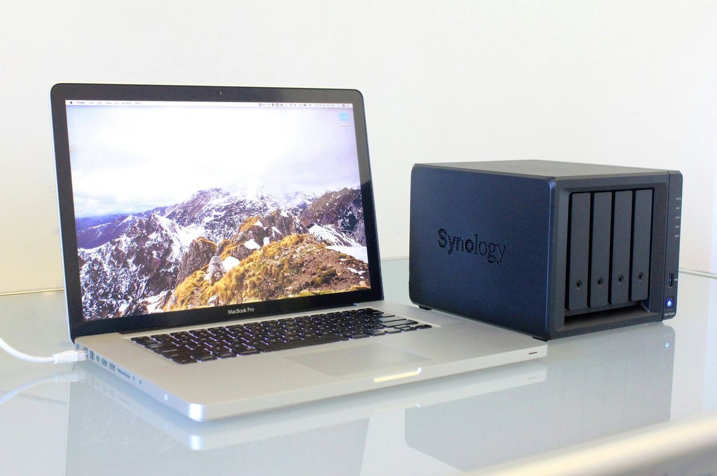 MacBook Pro et NAS 4 baies installés sur un bureau